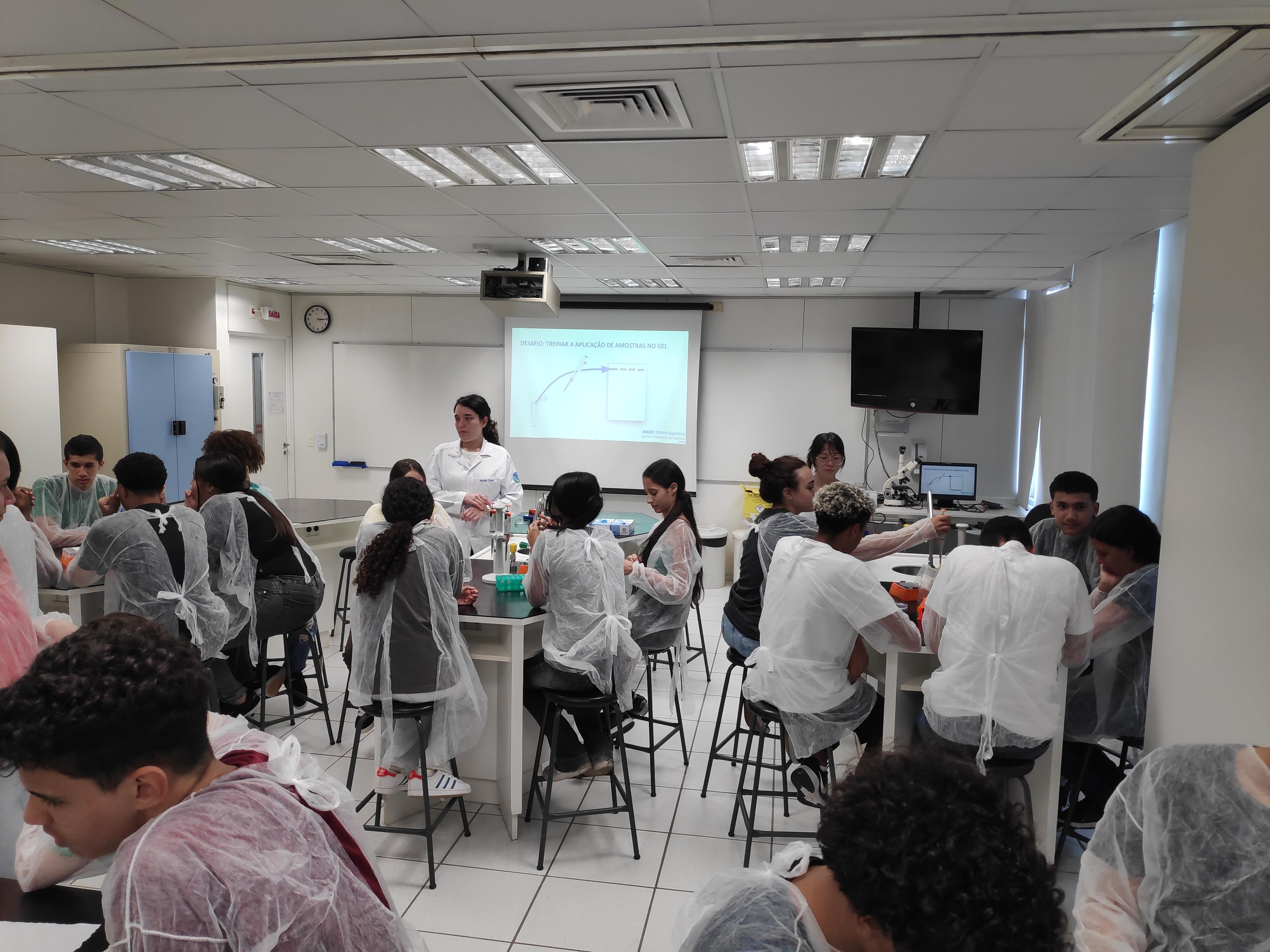 Grupo de estudantes aprendendo sobre equipamentos de laboratório