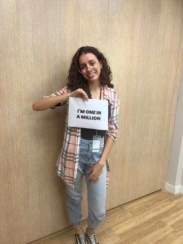 One of our students holding a paper celebrating her place as one in one million teenagers impacted by ABE.