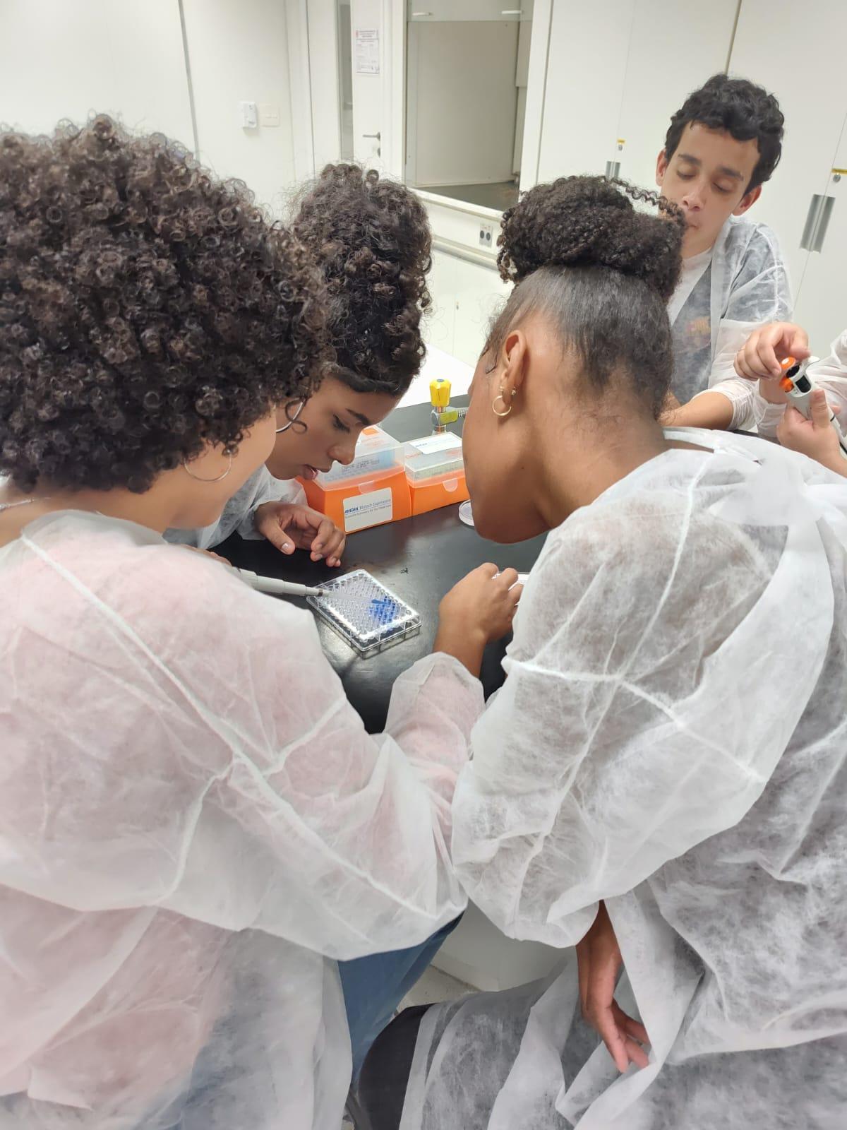 Alunas estruturando uma imagem usando micropipetas e placa de elisa