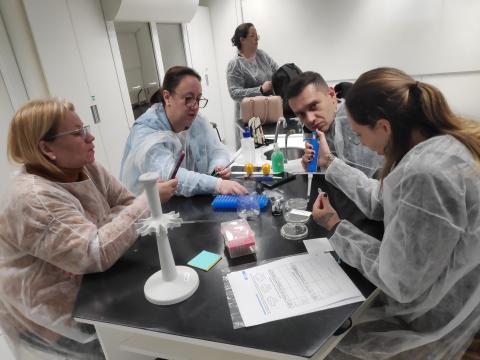 Teachers applying bacteria samples to agar plates