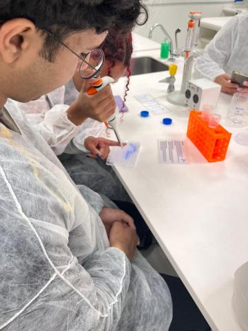 Estudantes produzindo uma imagem com micropipetas e corantes alimentícios