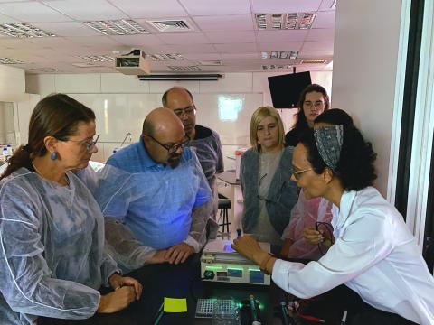 Professores observando o resultado de um procedimento de eletroforese.