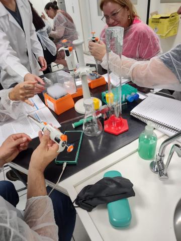 Professores aprendendo a usar a micropipeta