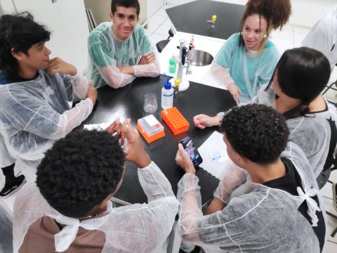 Grupo de estudantes aprendendo sobre equipamentos de laboratório