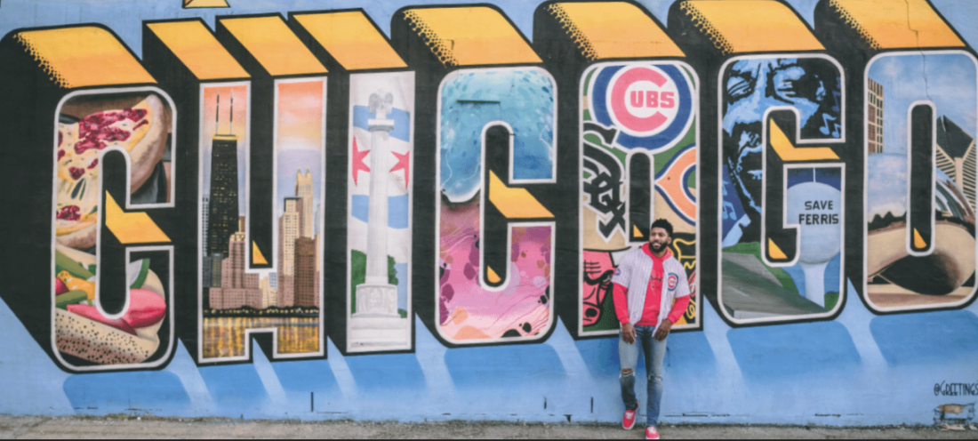 Man standing by wall art saying "Chicago"