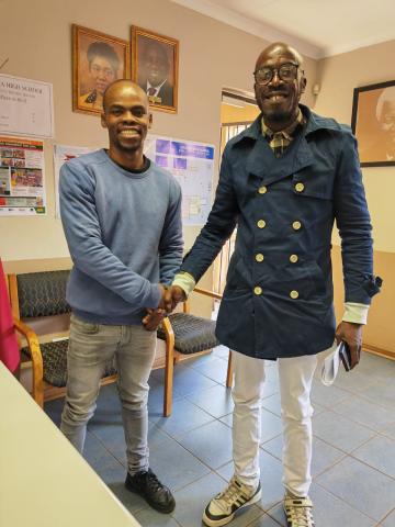 Mr Nyoni shakes hands with Mr Vanxa, a life sciences teacher from Cultura High School. Both men are smiling